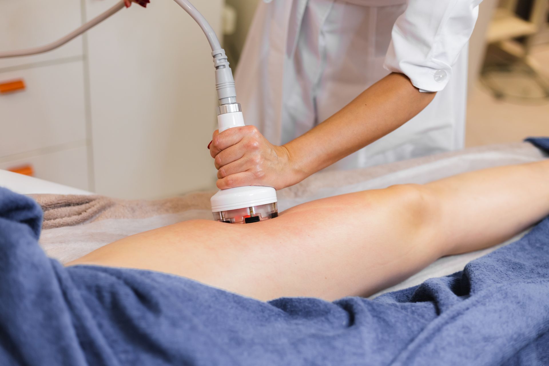 a woman is getting a cavitation treatment on her leg .