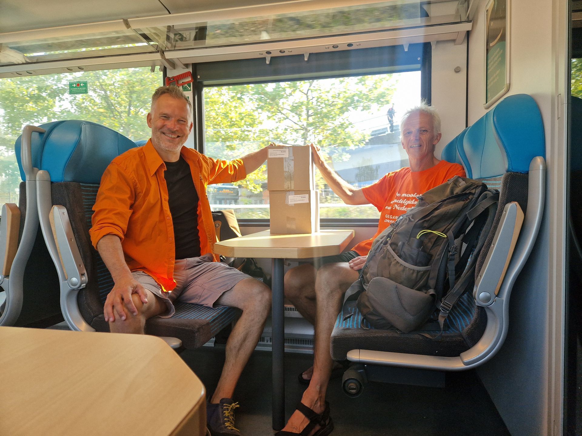 Uitgevers van der Mark en Vellinga in de trein op weg naar een presentatie van een gids