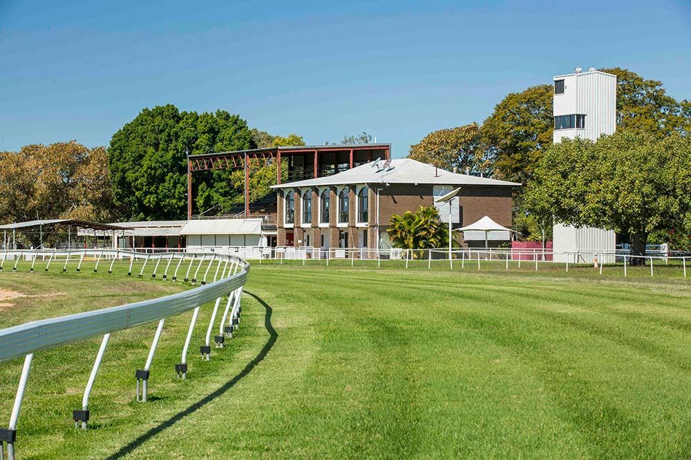 Grass Field Surrounded by Buildings in Emerald — AMP Amusements In Emerald, QLD