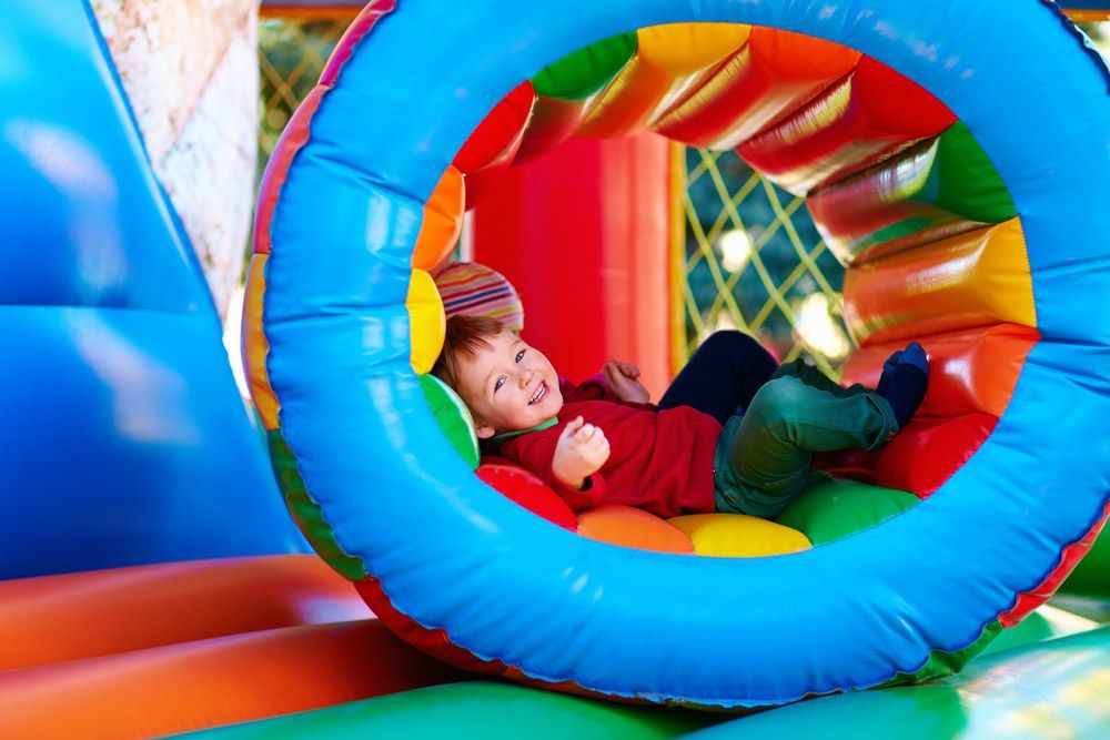 Happy Kids Playing On An Inflatable Attraction Carnival — AMP Amusements In Mackay, QLD
