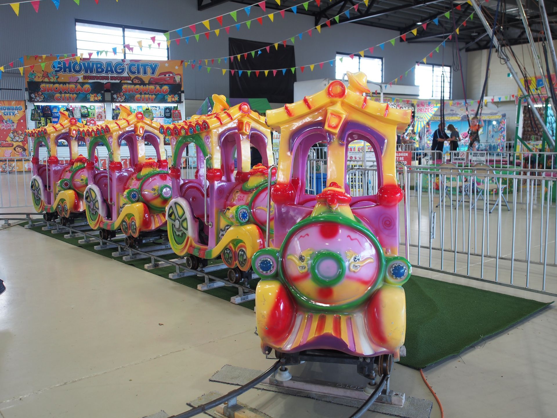 A colorful train is sitting on a track in an amusement park — AMP Amusements In Rockhampton, QLD