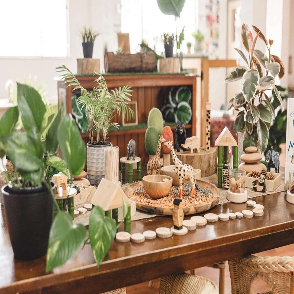 A wooden table filled with lots of toys and plants.