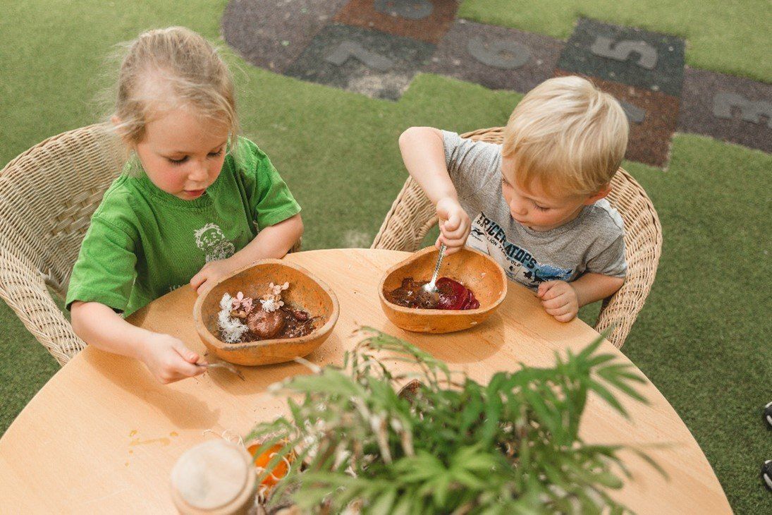 A boy and a girl are sitting at a table with bowls of food.