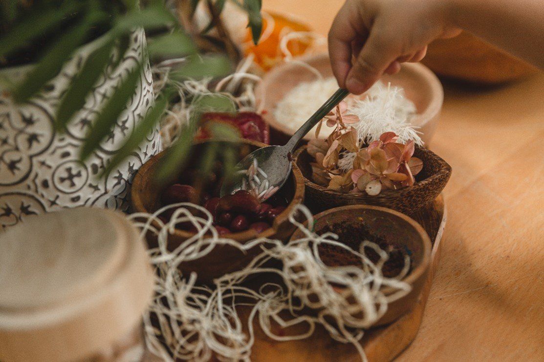 A person is holding a spoon over a bowl of food.