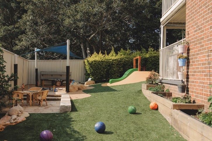 A brick building with a playground in front of it.