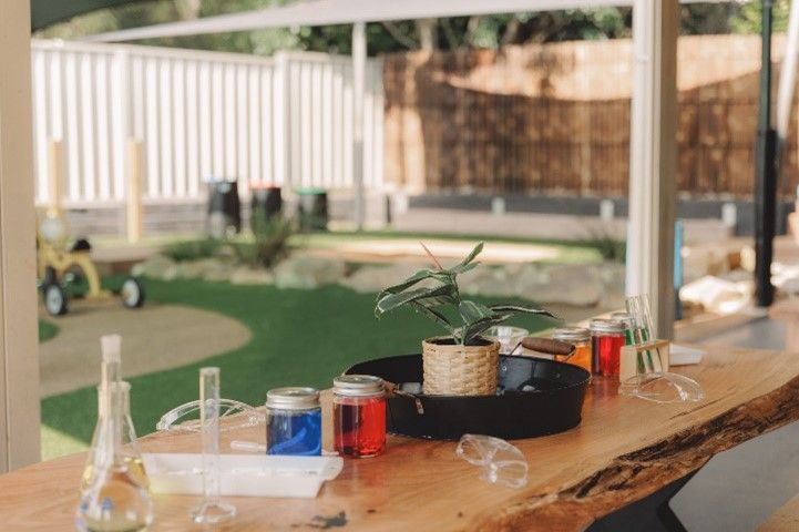 A wooden table with jars and bottles on it.