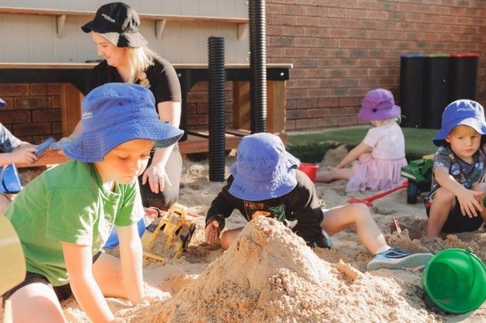 A group of children are playing in a sandbox.