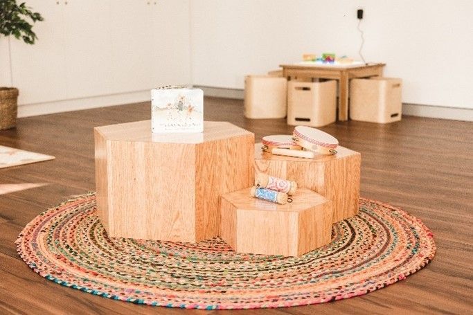 A room with wooden blocks and a rug on the floor.