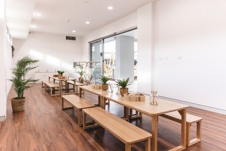 A room with wooden tables and benches in it.