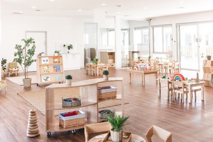 A large room with tables and chairs in a classroom.