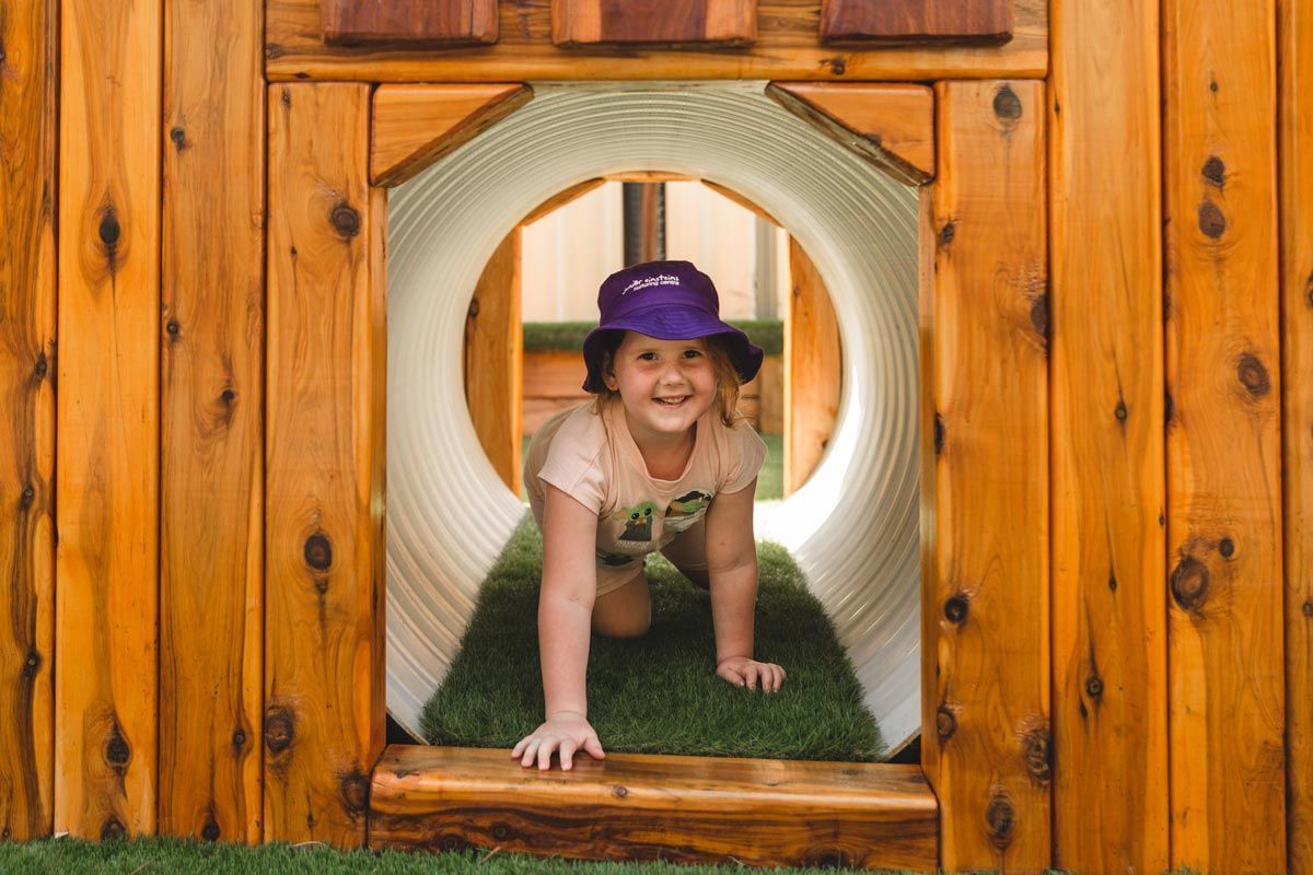 A girl with purple hat playing on the obstacle
