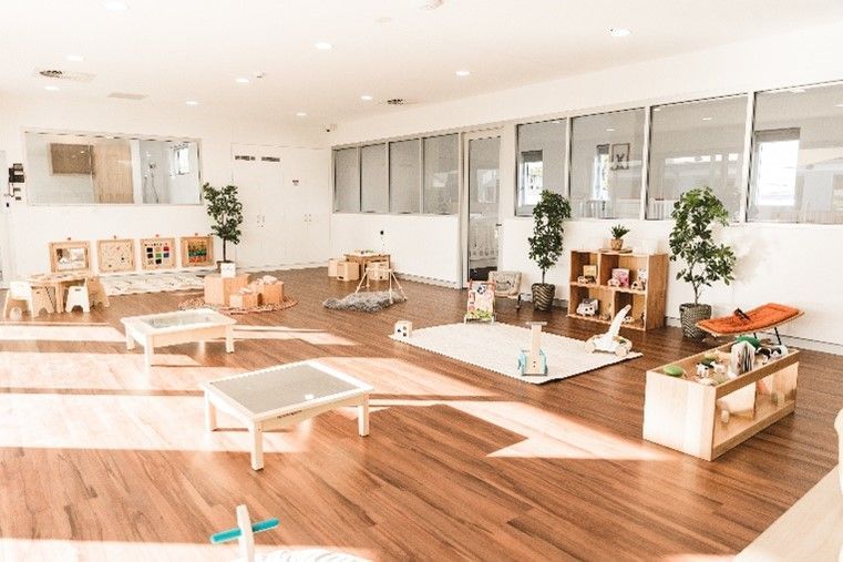 A large room with wooden floors and lots of toys in it.