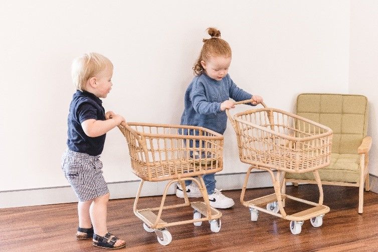 A boy and a girl are playing with shopping carts.