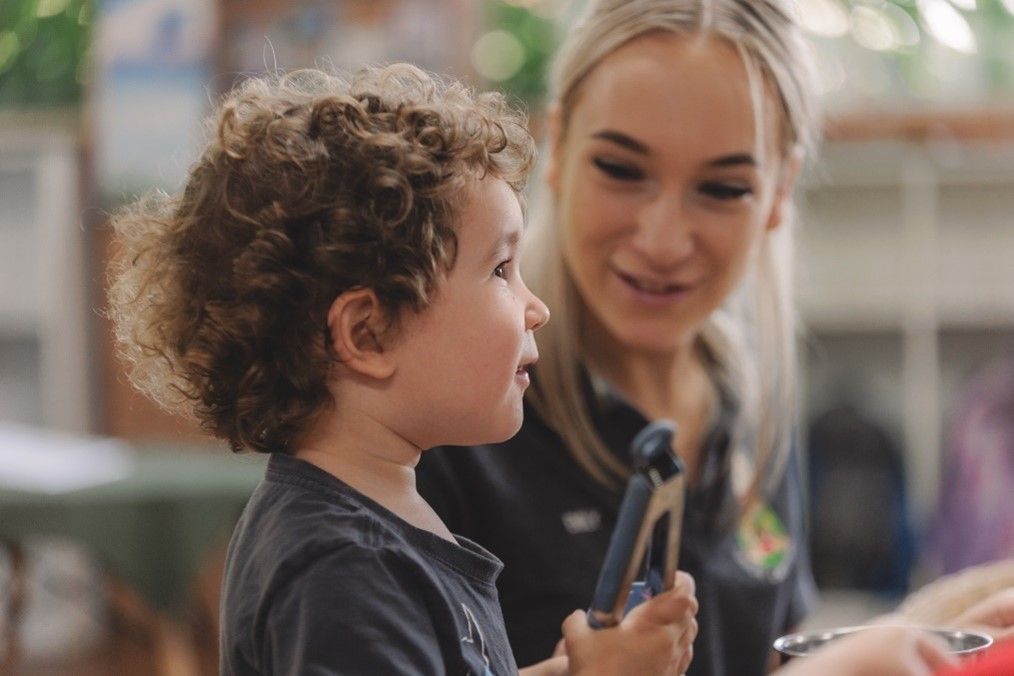 A Woman Is Talking to A Young Boy — Shell Heights, NSW — Junior Einsteins A woman is talking to a young boy who is holding a toy.