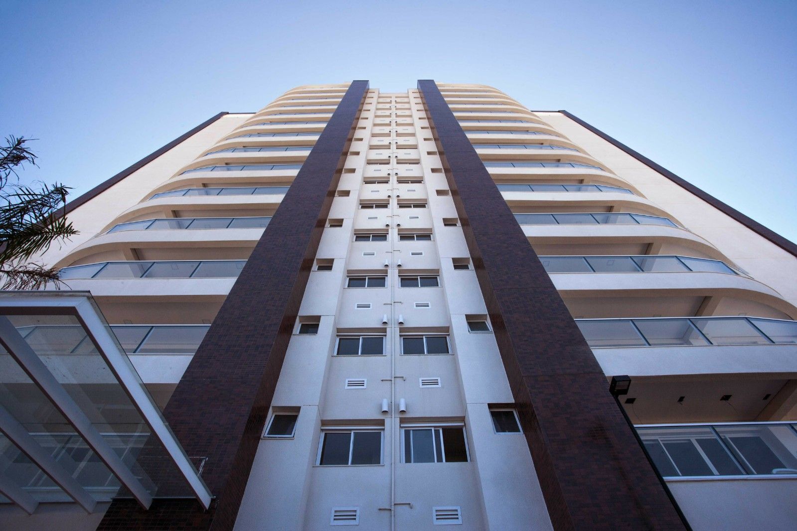 Olhando para um prédio alto com um céu azul ao fundo