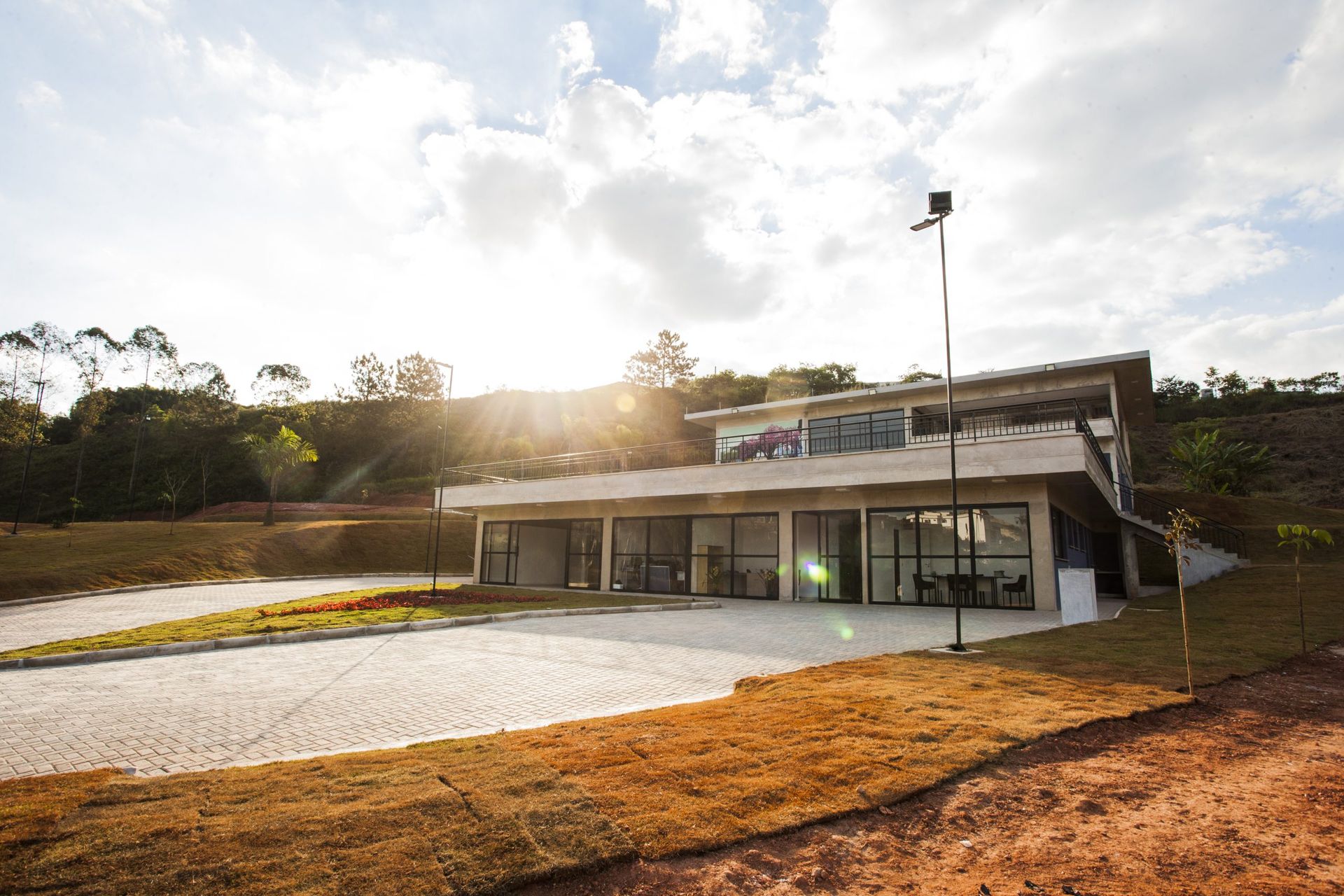 Uma casa grande com muitas janelas fica no topo de uma colina.