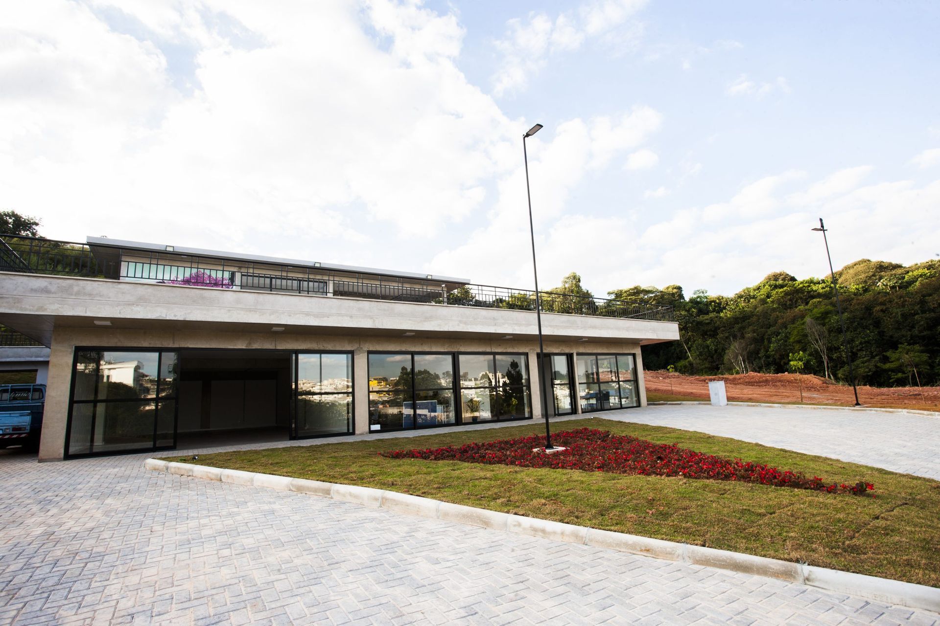 Um grande edifício com muitas janelas cercado por grama e árvores.