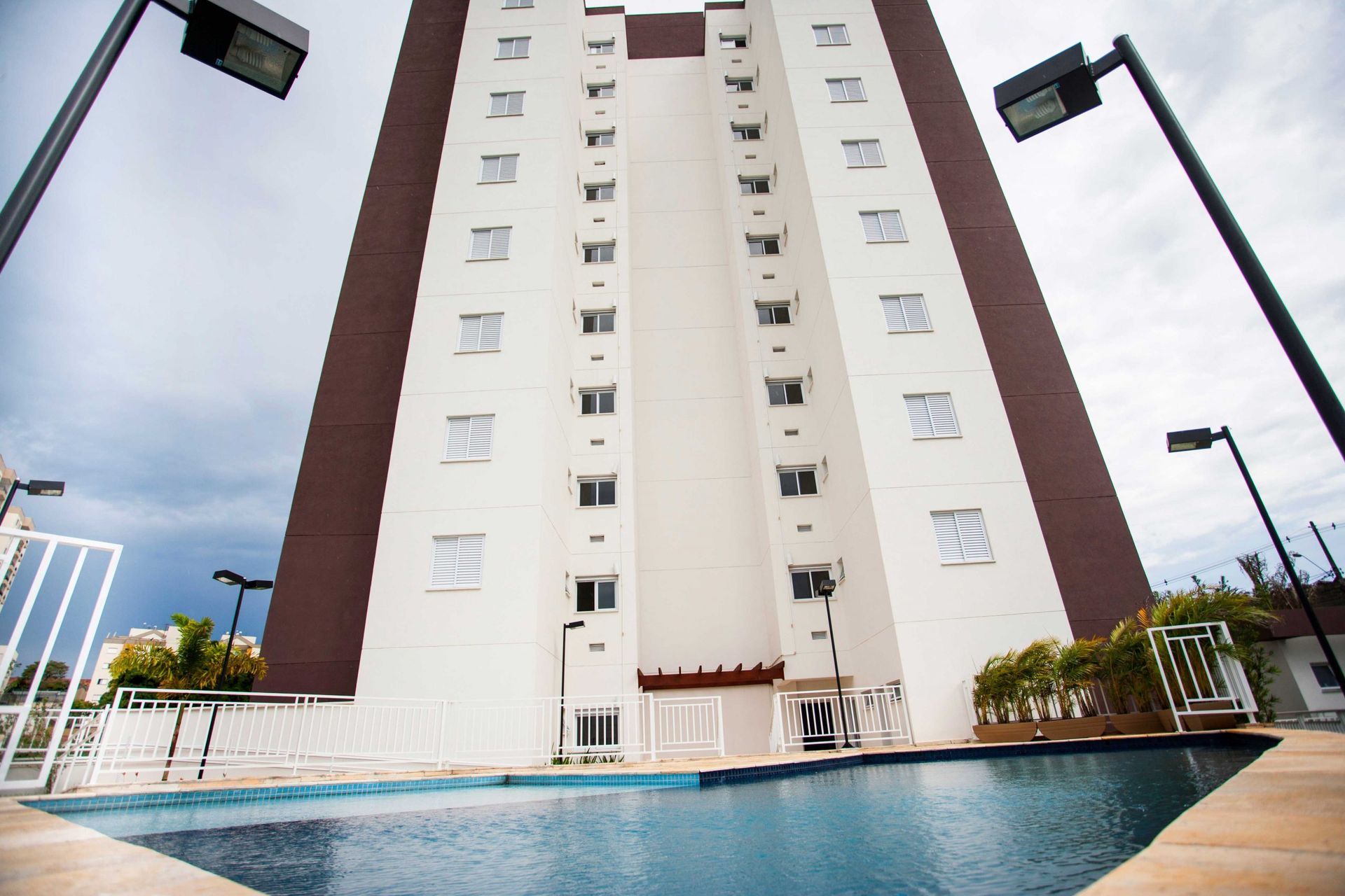 Um edifício alto com uma piscina na frente