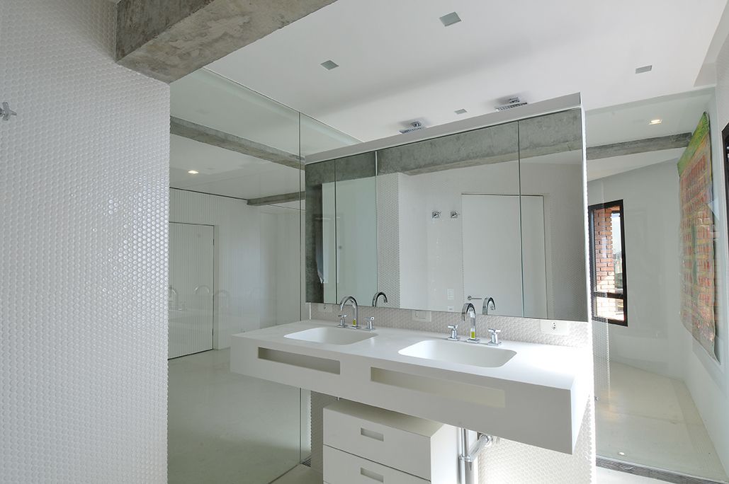 Um banheiro com duas pias e um espelho grande