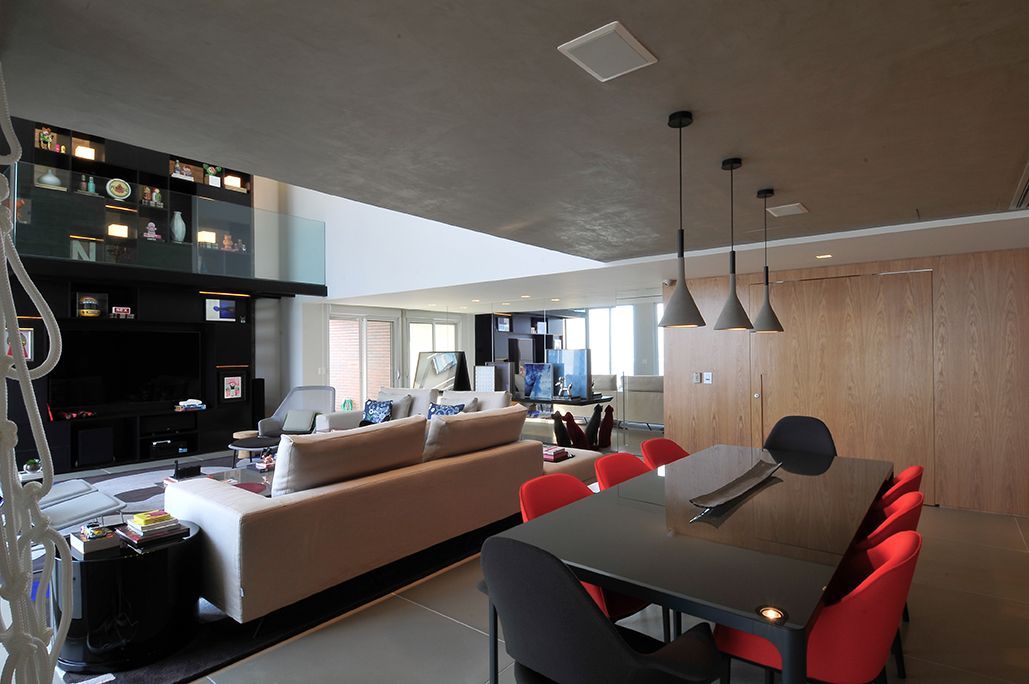 Uma sala de estar com uma mesa preta e cadeiras vermelhas