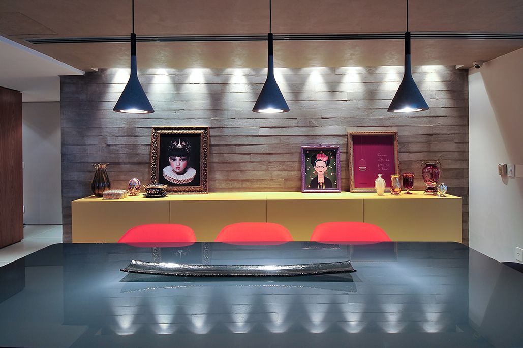 Uma sala de jantar com uma mesa preta e cadeiras vermelhas