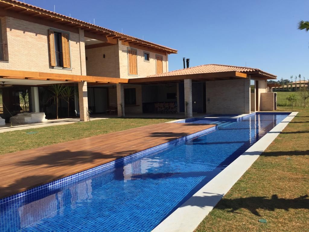 Uma casa grande com uma grande piscina na frente
