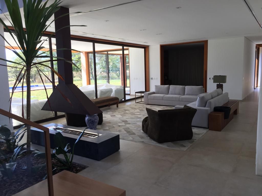 Uma sala de estar com um sofá e cadeiras e uma lareira