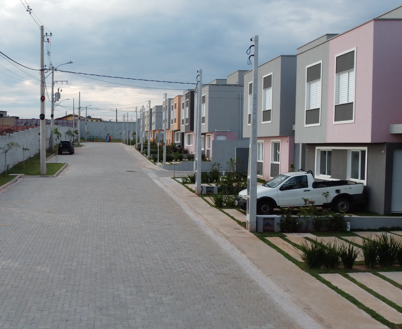 Um caminhão branco está estacionado em frente a uma fileira de casas