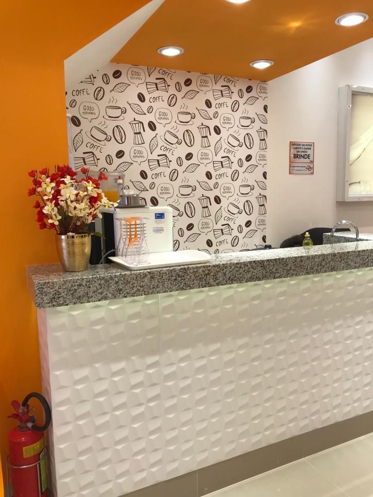 Um balcão em um restaurante com um vaso de flores nele.