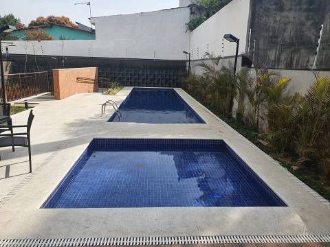 Há duas piscinas no quintal de um prédio.