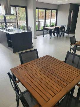 Uma sala grande com uma mesa de madeira e cadeiras.