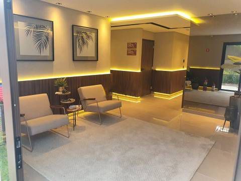 Uma sala de estar com duas cadeiras, uma mesa e um tapete.