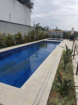 Há uma grande piscina no quintal de uma casa.