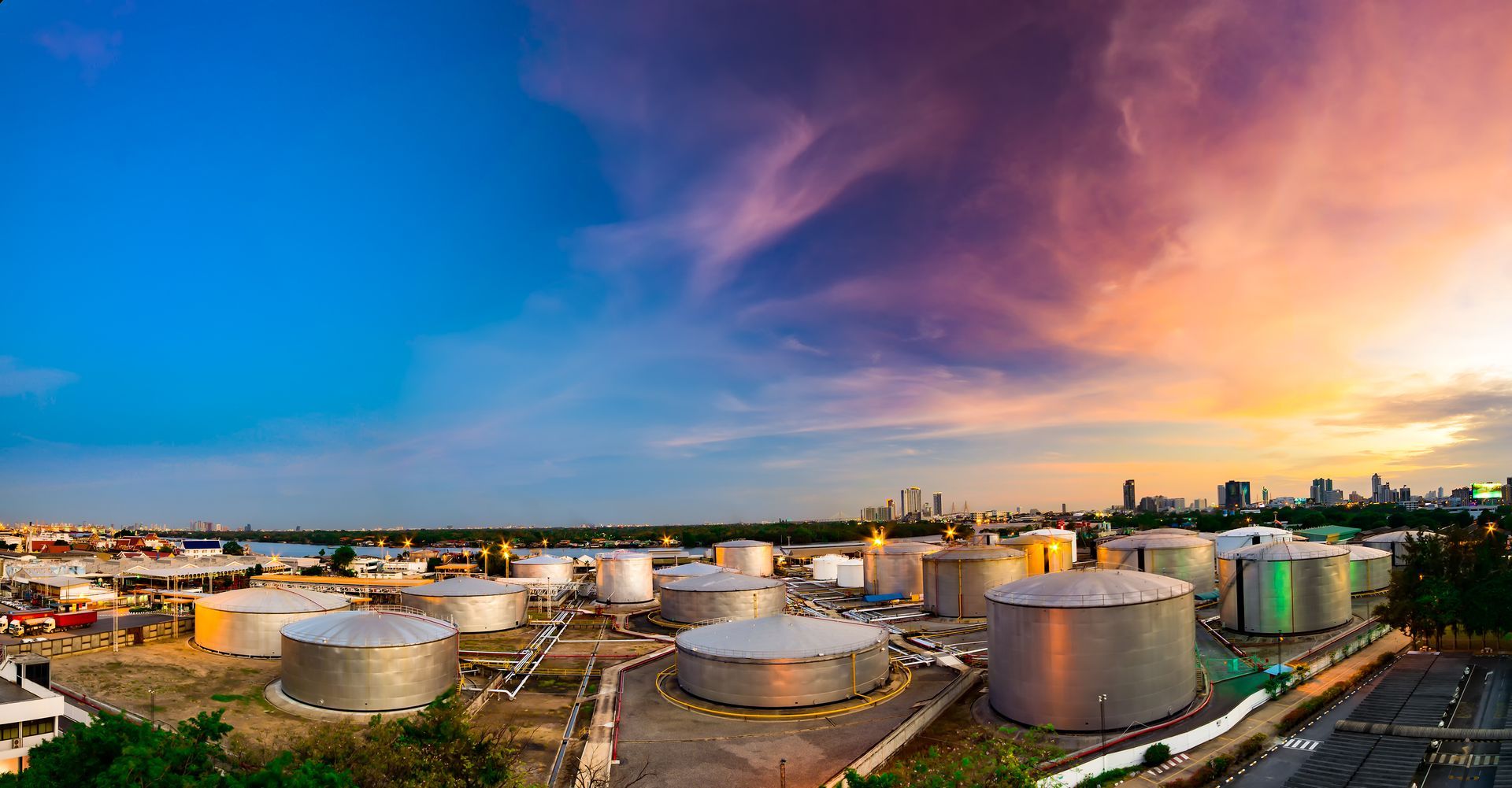 An aerial view of a large oil refinery at sunset.