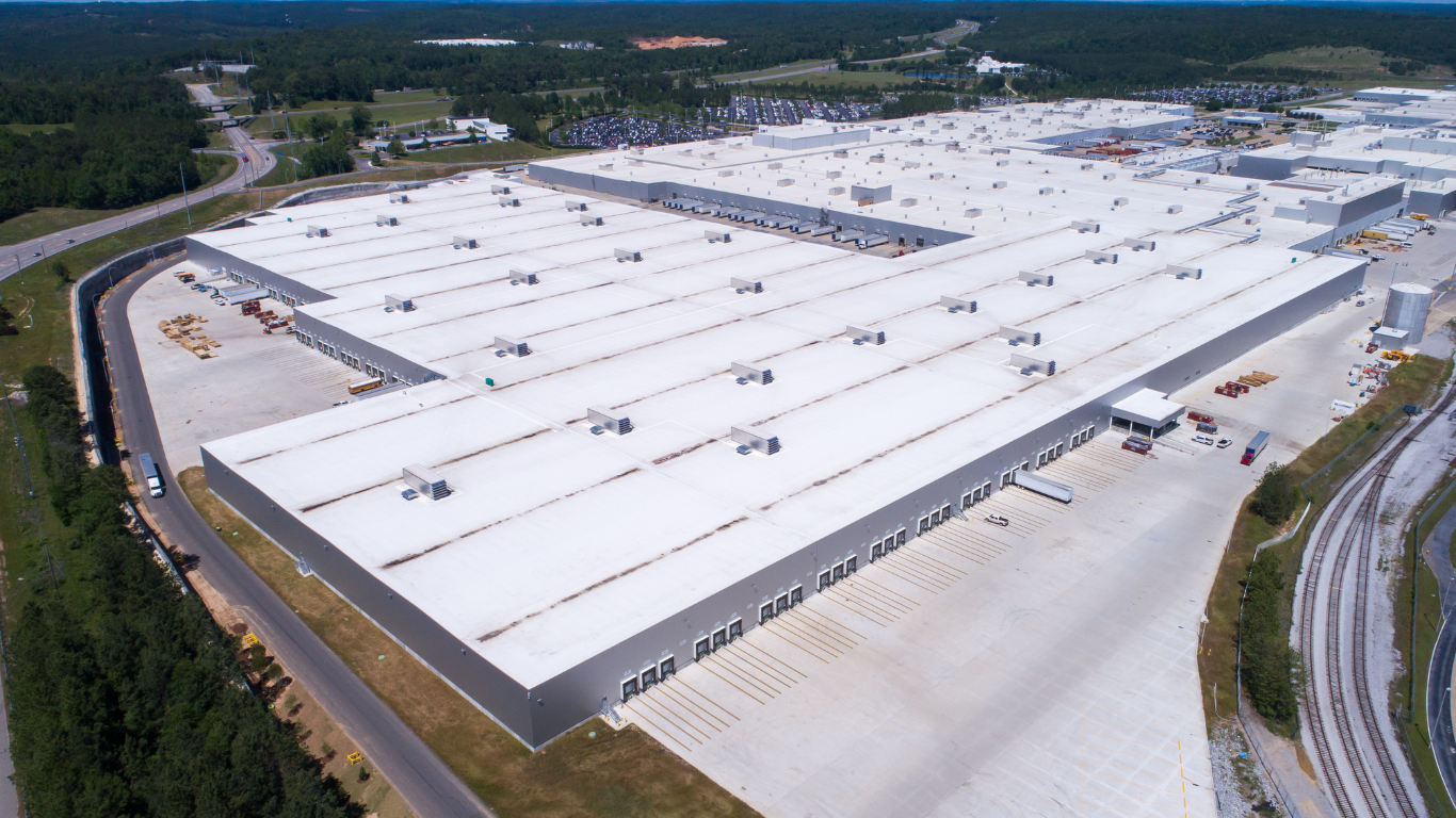 An aerial view of a large warehouse with a white roof.