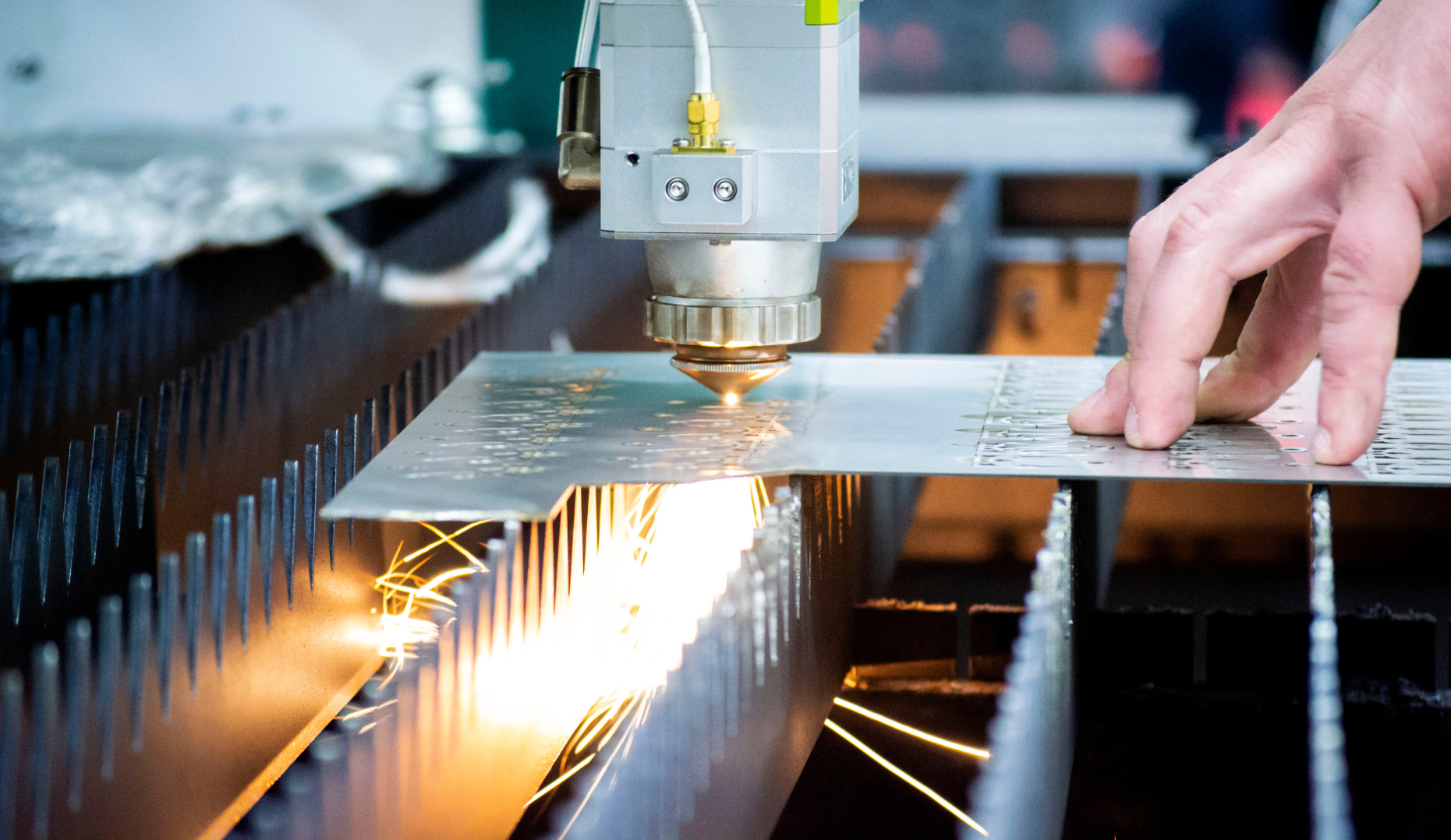 A person is cutting a piece of metal on a machine.