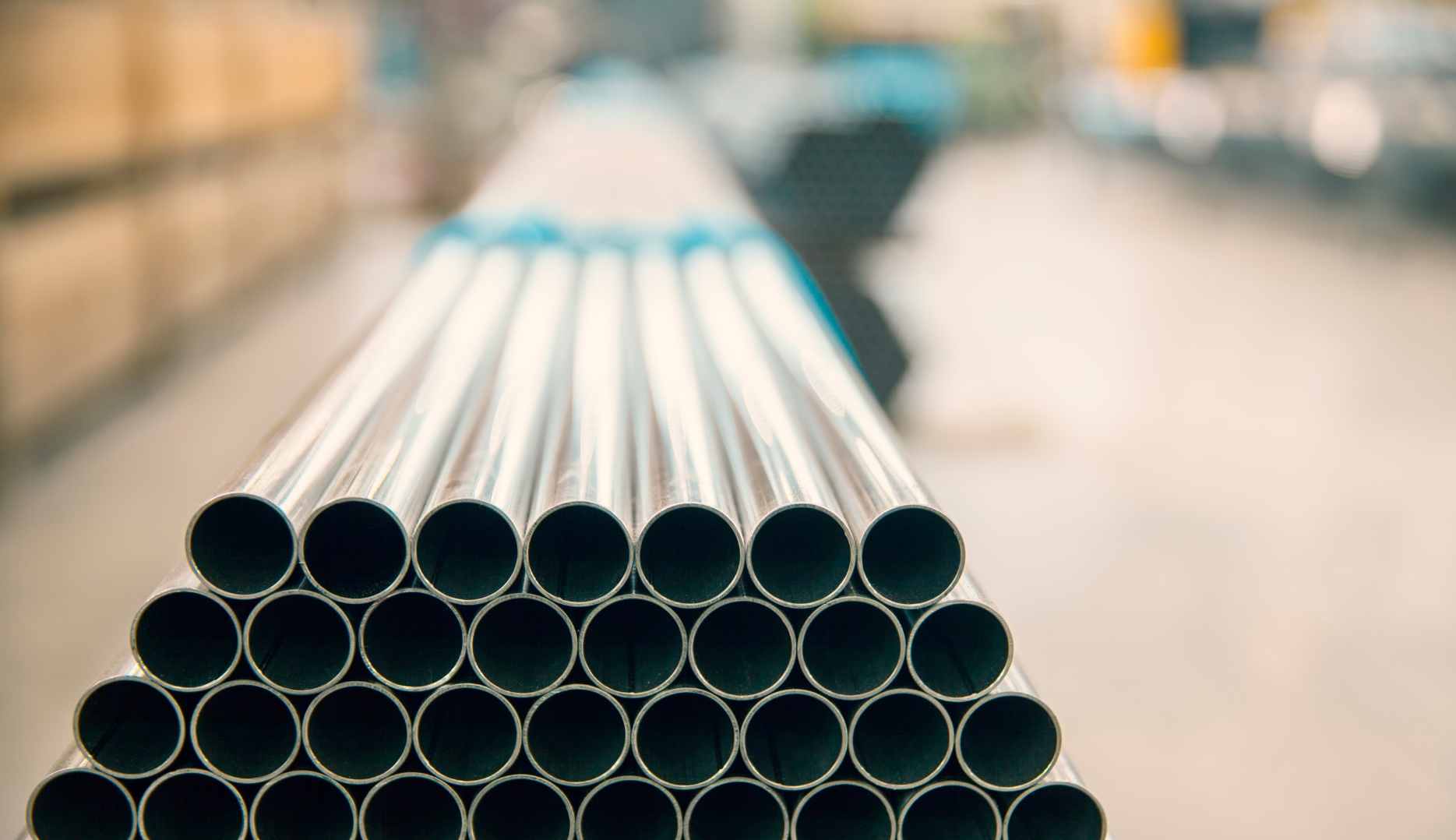A close up of a stack of metal pipes in a factory.