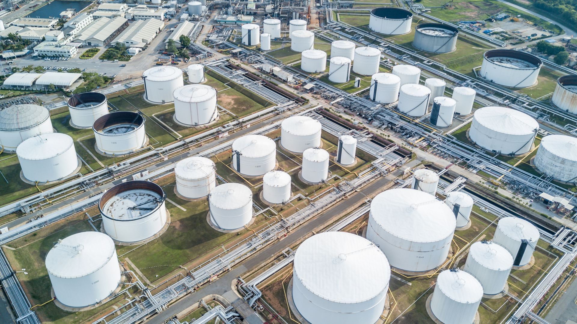 An aerial view of a large oil refinery with lots of tanks.