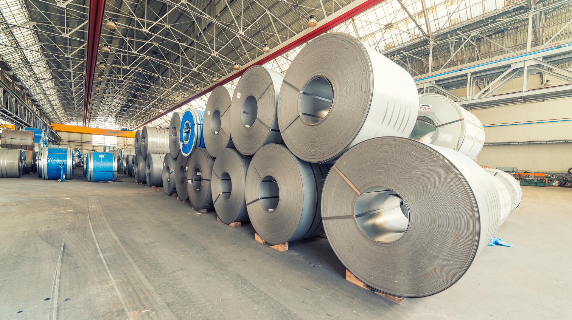 A warehouse filled with rolls of steel in a factory.