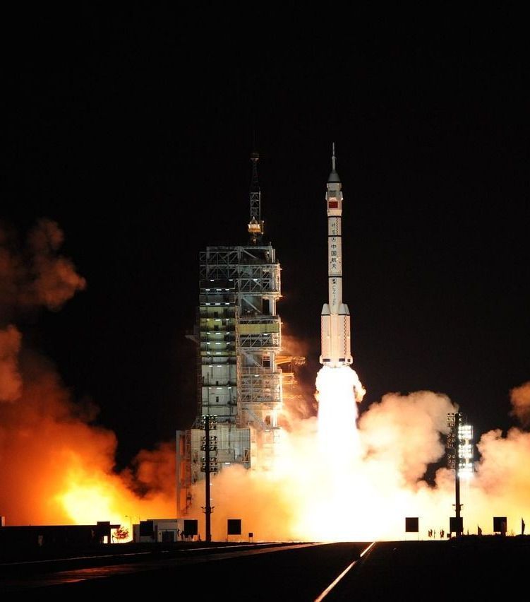 A rocket is being launched at night with smoke coming out of it
