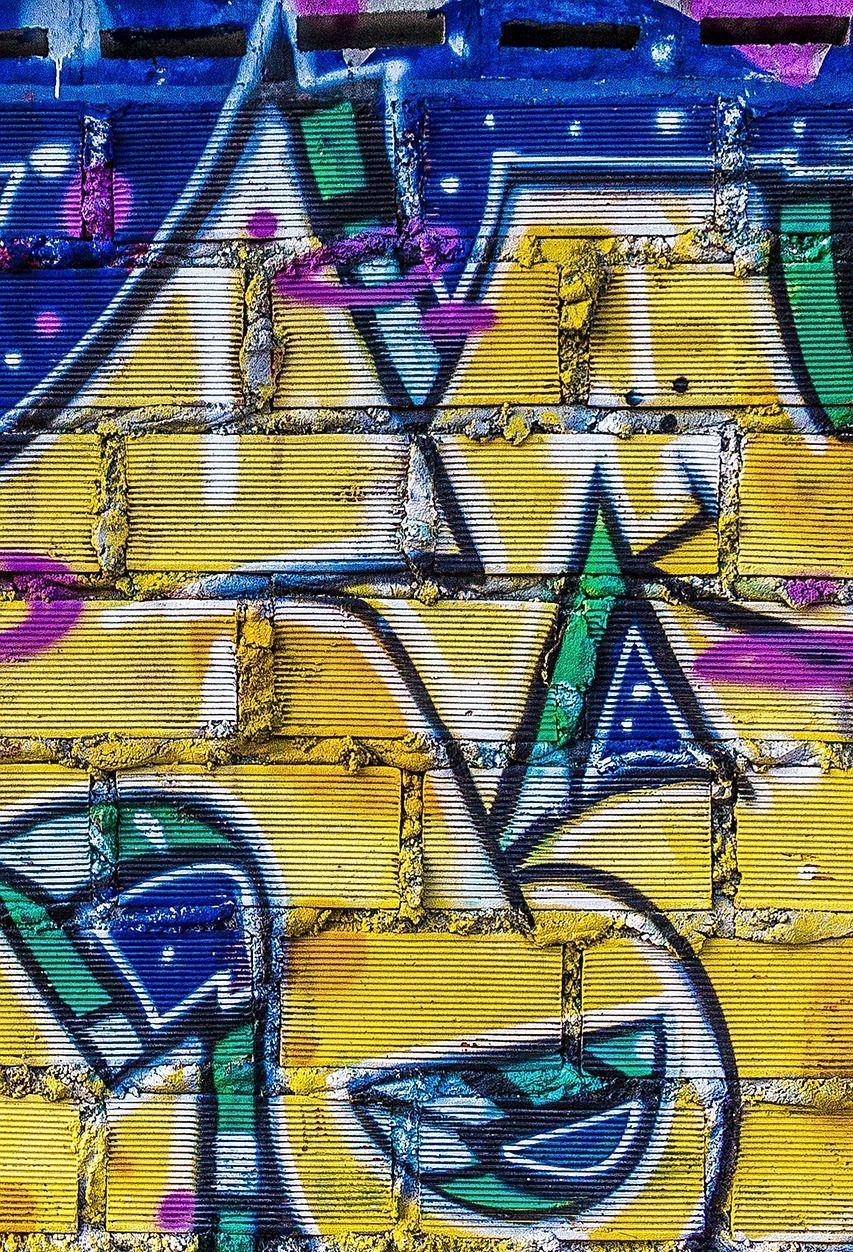 A close up of a wall with graffiti on it.