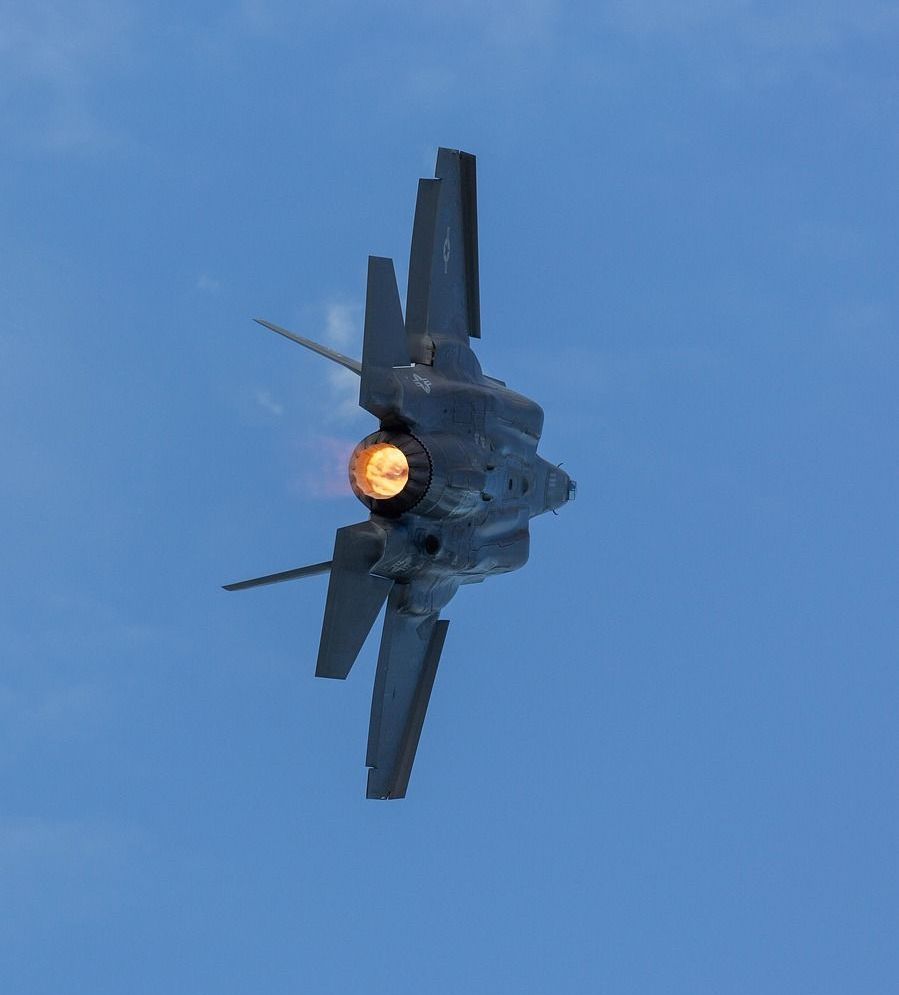 A fighter jet is flying through a clear blue sky