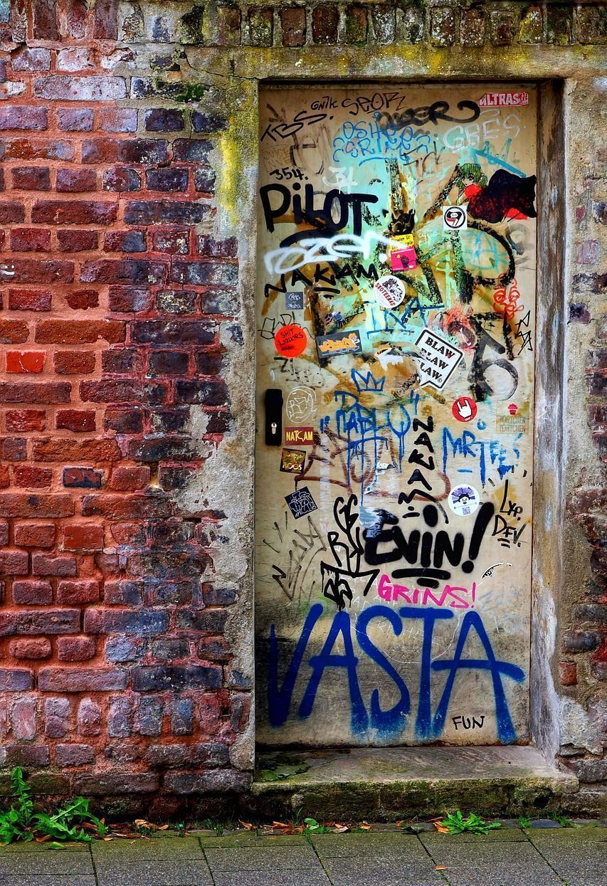 A brick wall with graffiti on it including the word asta