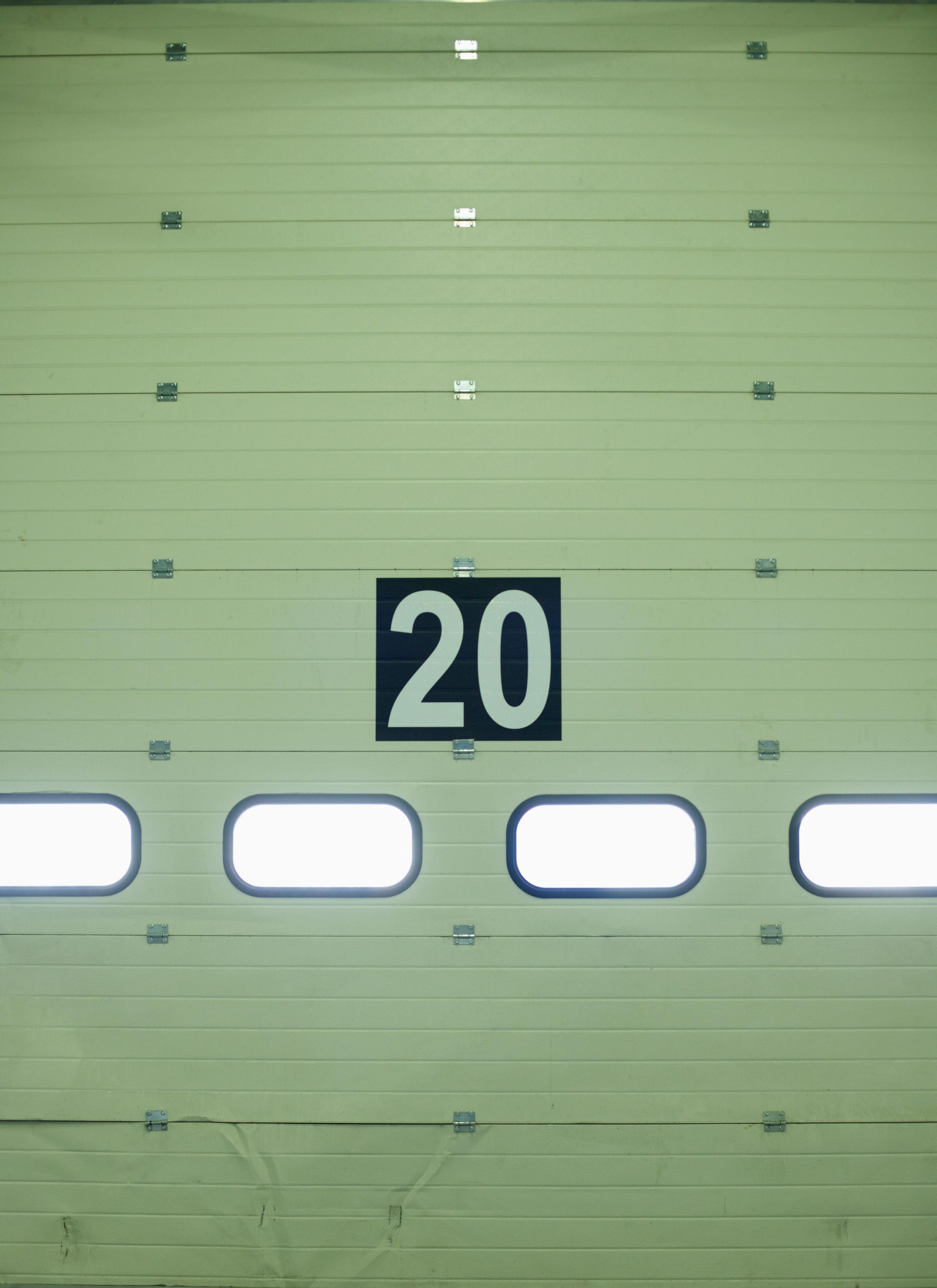 Closed industrial garage door with number 20 on a black square.