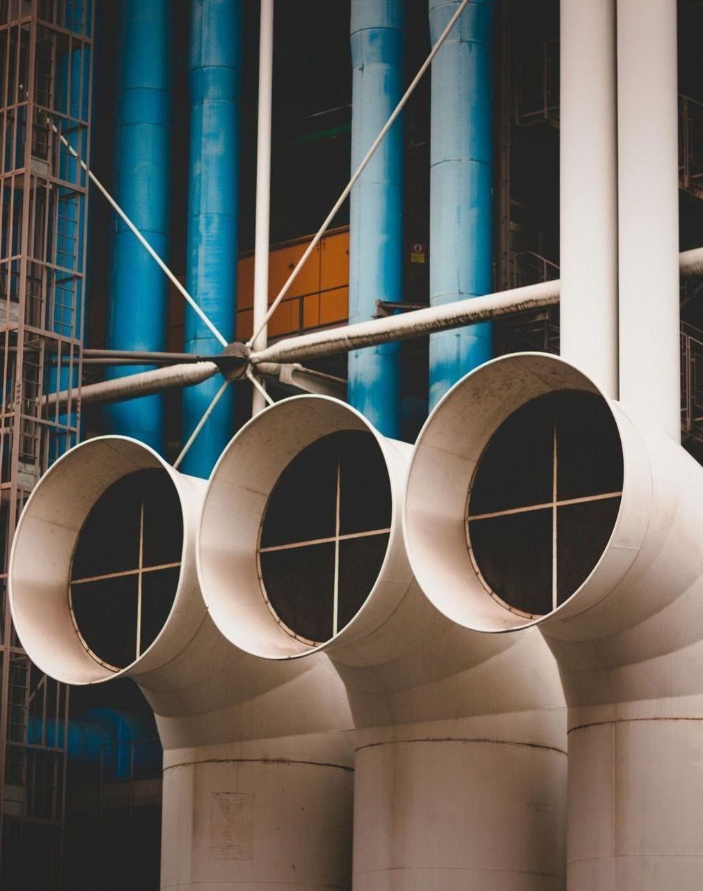 A row of white pipes with blue pipes in the background