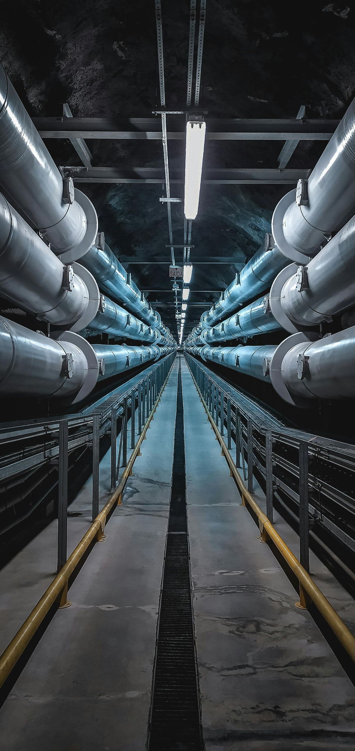 A tunnel filled with lots of pipes going through it.