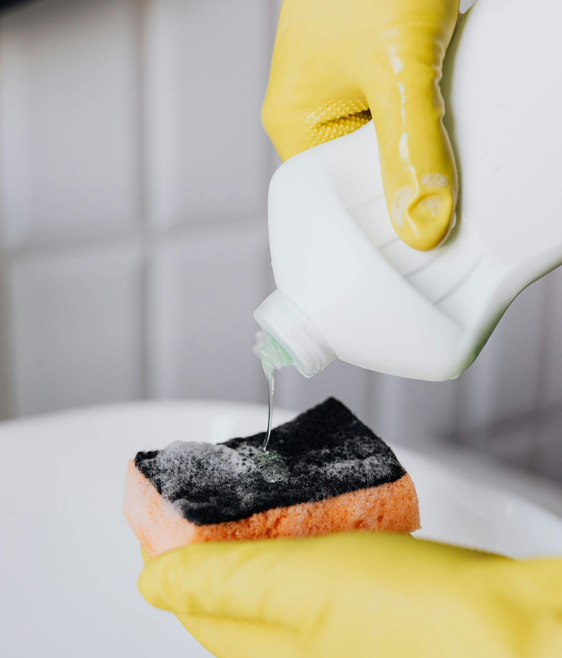 A man in a black shirt and black gloves is preparing food in a kitchen