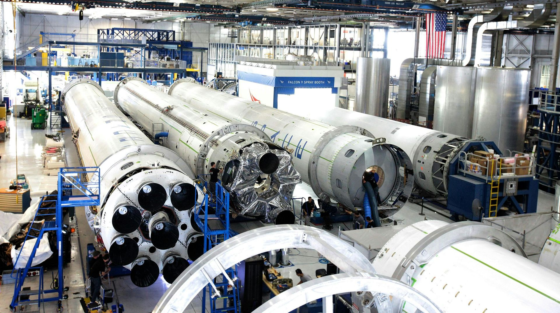 Inside SpaceX factory: partially built rockets, workers, machinery.