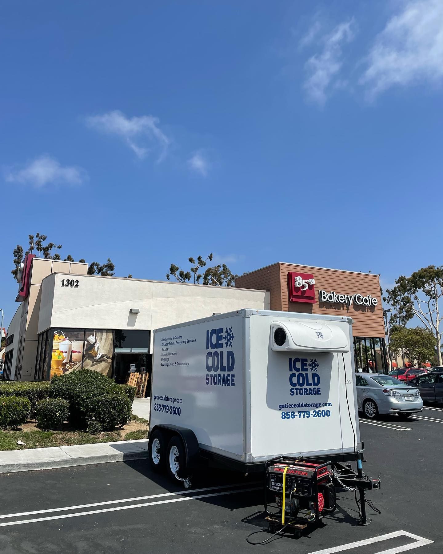 A white trailer that says keep cold is parked in a parking lot.