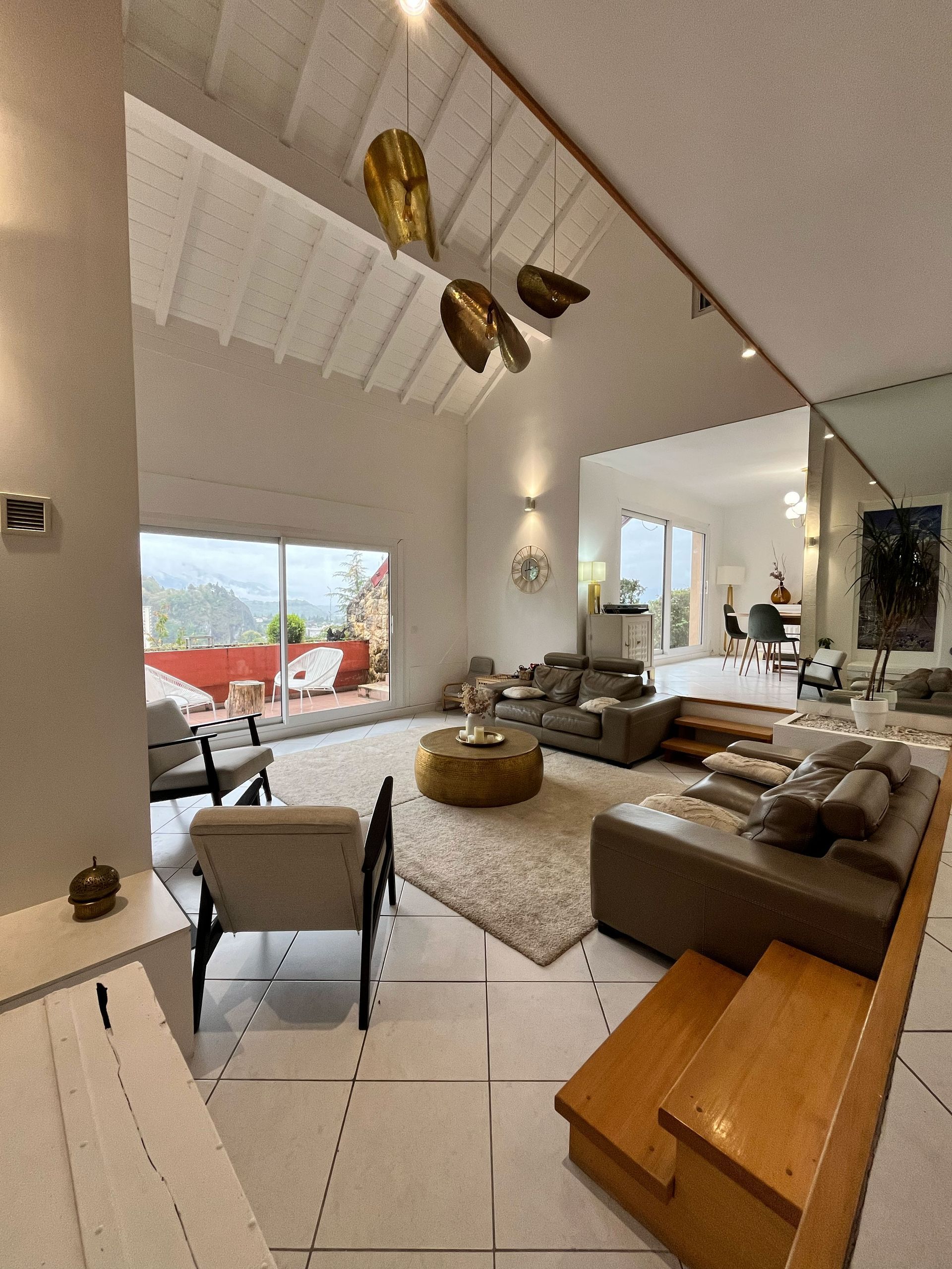 Salle de bains moderne avec baignoire îlot, douche en verre, meuble-lavabo en bois et porte-serviettes.